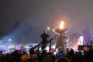 Amanda Demmerle, 2021 Athlete of the Year, lights the Opening Ceremony cauldron at the Empire State Winter Games on Mirror Lake in Lake Placid, N.Y., on Thursday, February 3, 2022. (Photo by Toluwanimi Fajolu/Newhouse School)