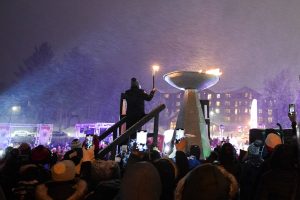 Amanda Demmerle, 2021 Athlete of the Year, lights the Opening Ceremony cauldron at the Empire State Winter Games on Mirror Lake in Lake Placid, N.Y., on Thursday, February 3, 2022. (Photo by Toluwanimi Fajolu/Newhouse School)